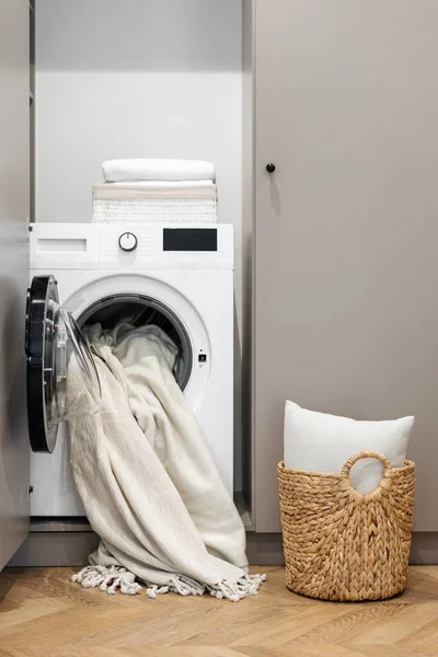 Collection of dirty clothes in basket and near washing machine in modern room interor design. Laundry idea. Home comfort. Household duties. Cleaning service needed