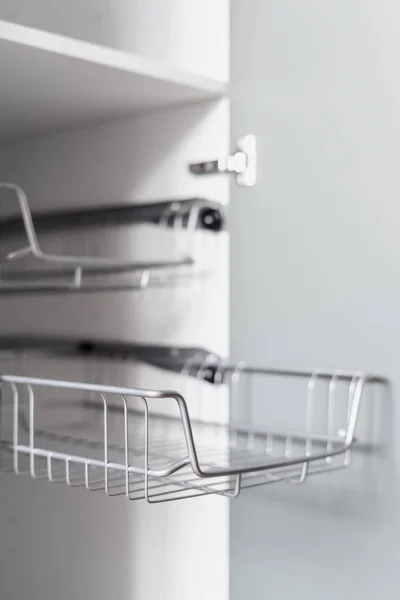 empty metal shelf for clothes in wooden closet or storage organization concept in dressing room, closeup