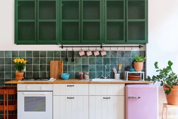kitchen with white cupboard, wooden worktop, modern appliances, retro refrigerator, utensils and potted plants, stylish interior