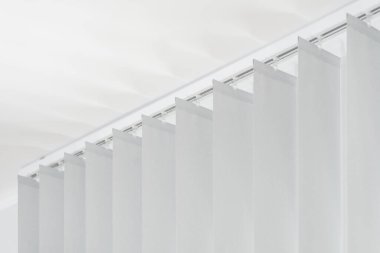 Tavandaki gri dikey panjurlar ofisteki pencerenin güneş ışığını kapatıyor. Beyaz kumaşlı külüstür araba. Dairede ev dekorasyonu