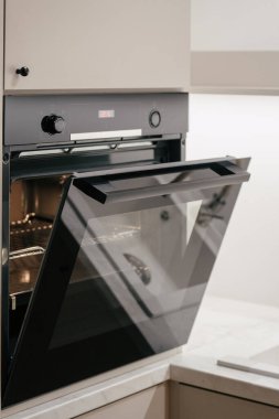 Modern bir dairede ev aletlerinin reklamını yapmak. Cam kapılı elektrikli fırının dikey görüntüsü. Mikro dalga fırını olan çağdaş mutfak dolabı.