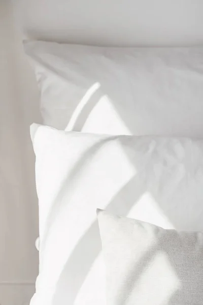 Close up view of clean pillowcases on anatomical pillows with latex memory foam material in hotel room. Concept of healthy sleeping, recreation and relaxation. Apartment with white linen in bedroom