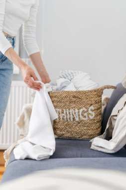 Kesilmiş kadın pozu temiz çarşaf ya da sepetten çarşaf almak apartman, ev işi ve çamaşır konsepti oturma odasında