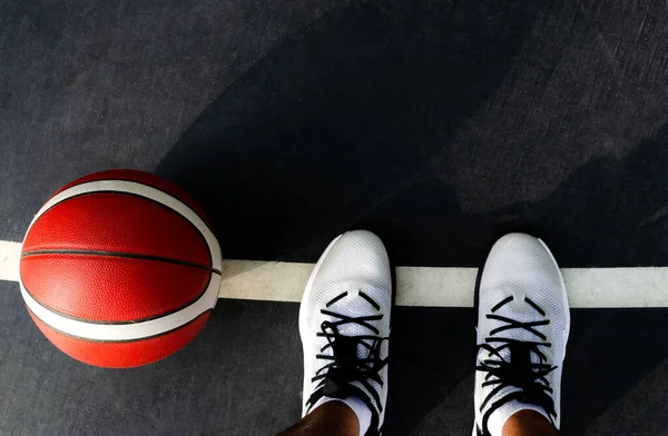 Basketball Player His Feet Black Court Orange Ball Next Him — Stok fotoğraf