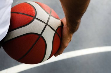 Belinde turuncu bir top olan genç ve güçlü bir basketbolcu. Çalışmaya hazırım. Kendine güveni tam. Büyüklük konsepti, korkusuzluk, spor.