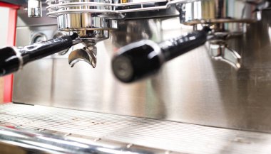 Bir kahve dükkanından parlak ve pırıl pırıl profesyonel bir kahve makinesine yaklaş. Sapı bulanık. Boşluğu kopyala. 