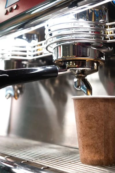 close-up of a vintage professional coffee machine filling an ecological take-away cup. the coffee comes out of the machine. ecofriendly concept.