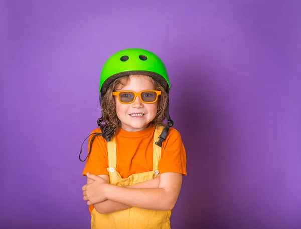 Portrait of a little girl in safe helmet and sun glasses in isolated on colorful background. Funny confident kid ready to make sport — Stock Photo, Image