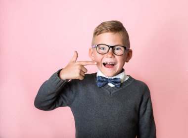 Çocuk kayıp dişlerini işaret ediyor. Bir dişi eksik okul çocuğu mutlu görünüyor. Süt dişli çocuk hediye bekliyor. Süt dişi olmayan bir öğrencinin portresini kapat.