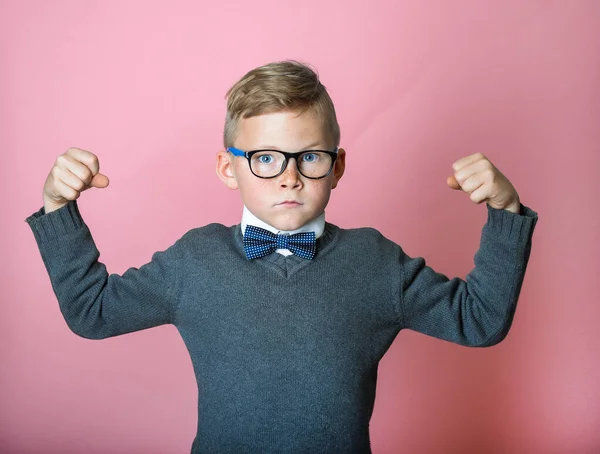 Zelfverzekerde jongen toont spieren. Sport kind jongen tonen zijn hand biceps spieren kracht. Leerling met bril. Nerd slimme jongen geïsoleerd op roze achtergrond. Terug naar school — Stockfoto