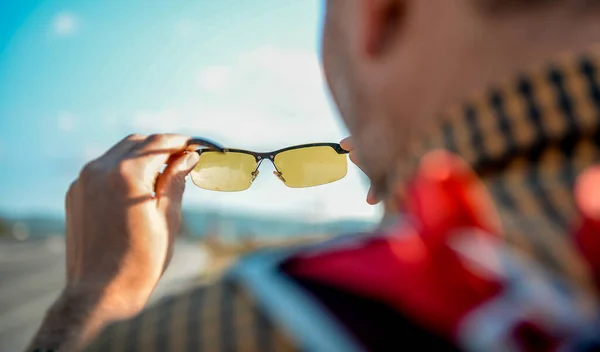 Man tourist look through glasses on beautiful nature. Abstract landscape view though eyeglasses. Blurry background. Vision concept.