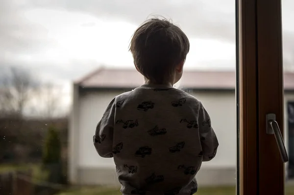 Little refugee child looking at the window. Alone kid in war. Russia war against Ukraine. Childrens tears. Save Ukraine — стоковое фото