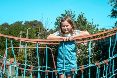 Filtre fotoğrafı. Yazın açık havada altı yaşında bir çocuk yüzü. Çocuk parkındaki küçük kızın portresi. Mutlu gülümseyen neşeli çocuk, gerçek duygu, kaygısız çocukluk konsepti