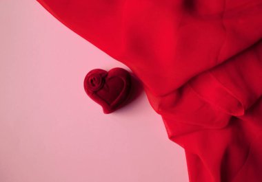 Pembe arka planda kırmızı kadife bir kalp ve kırmızı bir şal. 8 Mart. 14 Şubat.