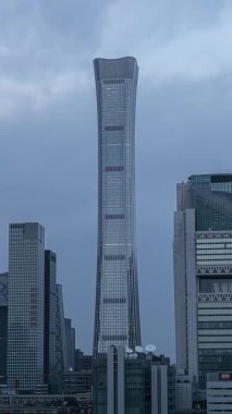 Pekin 'deki Dünya Ticaret Merkezi' nin dikey videosu. Büyük metropolün CBD finans bölgesindeki Çin 'in en yüksek binasının günden geceye geçişi.