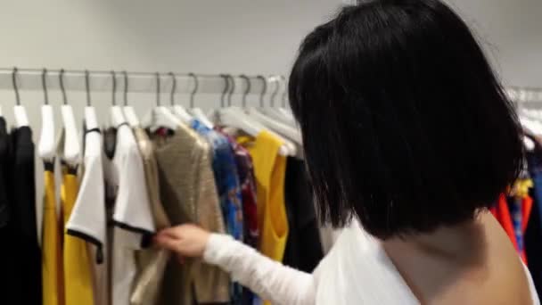 Modische Chinesinnen Kaufen Ein Asiatin Gehobenem Geschäft Die Kleiderständern Stöbert — Stockvideo
