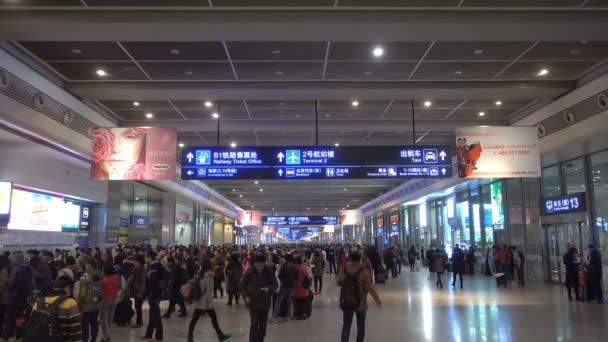 上海虹橋駅到着コース 大群衆と鉄道駅の低レベルで到着エリアの乗客 長い廊下に多くの旅行者が到着 — ストック動画
