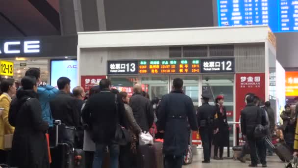 北京南駅のチケットチェックエントリゲートで乗客のキュー 混雑した近代的な鉄道駅で中国の高速列車に乗るために荷物やバッグに沿って多くの人々の群衆 — ストック動画