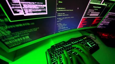 Şeytani hacker tarafından yazılan kötü niyetli kod geniş ekranda. Yasadışı kişisel bilgilere sızan siyah şapkalı bir programcı. Siber saldırıda kişisel bilgileri çalmak için fidye yazılımı saldırısı kodlanıyor.