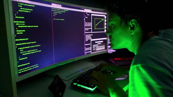 Seorang Hacker Jahat Mengetik Kode Hijau Dalam Kegelapan Beberapa Layar — Stok Video