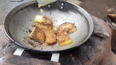 Ahşap sobada kızarmış balık. Hindistan 'da geleneksel yemek pişirme tarzı. Yiyecek, toprak ocağında yakılan odun ateşiyle pişiriliyor. Bir Hint köyü manzarası.