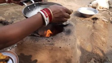 Ahşap sobada kızarmış balık. Hindistan 'da geleneksel yemek pişirme tarzı. Yiyecek, toprak ocağında yakılan odun ateşiyle pişiriliyor. Bir Hint köyü manzarası.