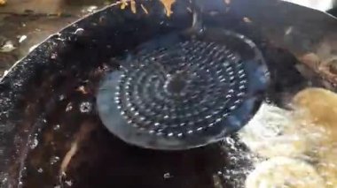 Jalebi kızartma tavasında tatlı yapıyor. Jalebi Hindistan 'da popüler bir tatlı atıştırmalıktır. Derin kızartma maida un hamuru dairesel şekillerde yapılır, sonra şeker şurubuna batırılır. Birçok isim var; jilebi, jilipi, zulbia, mushabak, zlabia, orzalabia..