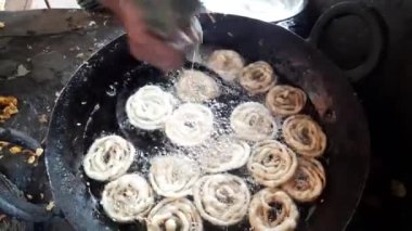 Jalebi kızartma tavasında tatlı yapıyor. Jalebi Hindistan 'da popüler bir tatlı atıştırmalıktır. Derin kızartma maida un hamuru dairesel şekillerde yapılır, sonra şeker şurubuna batırılır. Birçok isim var; jilebi, jilipi, zulbia, mushabak, zlabia, orzalabia..
