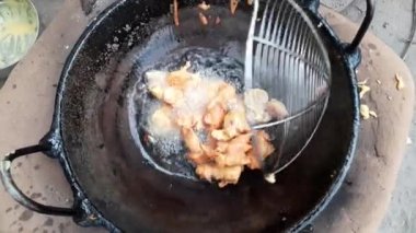 Pakora demir bir panoda filtreleniyor. Sokak satıcıları tarafından satılıyor. Patates ve soğan gibi sebzeler, Ingram un hamuru ve bol yağda kızartılmış. Pakora bir Hint yemeğidir..