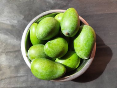 Siyah arka planda çiğ mango. Mango popüler bir meyvedir, ayrıca meyvelerin kralı olarak da bilinir. Turşusu çok lezzetli. Pişirilir ve sebzeye dönüştürülür. Siyah arkaplanda yeşil mango. 