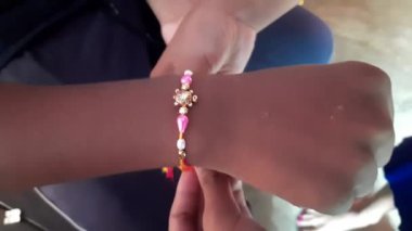 Kız kardeşi rakhi 'yi erkek kardeşine bağlıyor. Bu festival, Hindistan 'ın dört bir yanında kardeşlerin özverili sevgisi ya da ilişkisi olarak kutlandı. Hint festivali Raksha Bandhan. Hint kültürü.