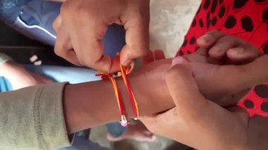 Kız kardeşi rakhi 'yi erkek kardeşine bağlıyor. Bu festival, Hindistan 'ın dört bir yanında kardeşlerin özverili sevgisi ya da ilişkisi olarak kutlandı. Hint festivali Raksha Bandhan. Hint kültürü.