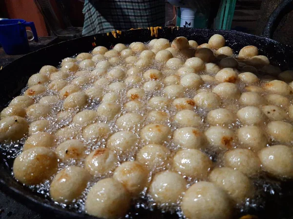 Gulab Jamun, an Indian sweet is being made in a sweet shop.  This sweet is being fried in hot oil.  It is then dipped in sugar syrup. A popular indian sweet. Traditional sweet of india. 