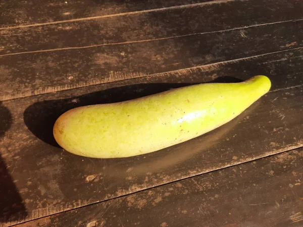 Bottle gourd in black background. It is avinegrown for its fruit. Its other names Calabash, Lagenaria siceraria, white flowered gourd,long melon,birdhouse gourd,New Guinea beanandTasmania bean.