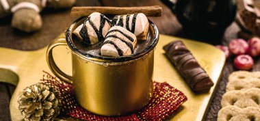 Marşmelov ve tarçınlı altın bardakta sıcak çikolata