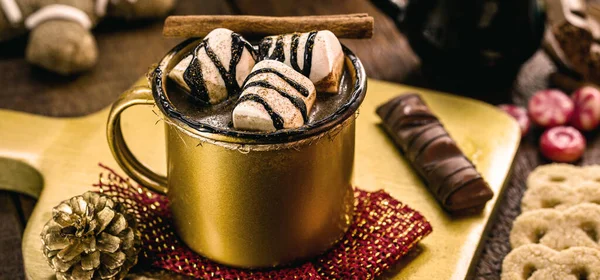 Marşmelov ve tarçınlı altın bardakta sıcak çikolata