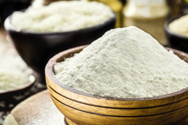 Pirinç unu şişirilmiş ahşap bir tencerede, glütensiz ve bütünsel bir malzeme.