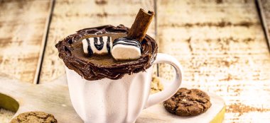 Bir fincan vejetaryen sıcak çikolata, dumanı tüten sıcak bir içecek, Noel ve yeni yılda kakao, tarçın, fındık ve kestane ile servis edilir.