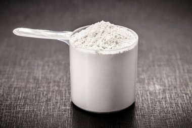 Amino acid supplement for sports use, creatine in a measuring spoon, hmb, bcaa, amino acid or powdered vitamin. sports nutrition concept