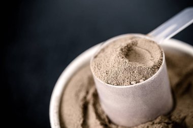 measuring spoon with casein and creatine, powdered food supplements, protein or amino acid used by athletes