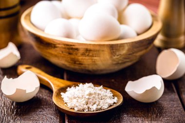 wooden spoon with ground eggshells, used white eggshell prepared for use as fertilizer, leftover food