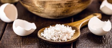 wooden spoon with ground eggshells, used white eggshell prepared for use as fertilizer, leftover food
