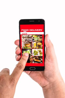 Akıllı telefon ekranına tıklayarak yemek siparişi veriyor.