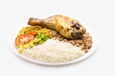 pirinç ve fasulye yemeği, büyük kızarmış tavuk budu, mısır ve bezelyeli domates salatası, izole edilmiş beyaz arka plan, geleneksel Brezilya yemeği.