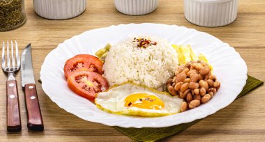 Bir tabak pirinç ve fasulye tipik Brezilya, kızarmış sosis, kızarmış yumurta, doğranmış sebze ve salata.