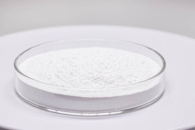 Petri dish with powdered Benzoyl Peroxide, used in the preparation of cream, lotion or gel in the treatment of acne and mild and moderate forms of dermatitis. Isolated white background, copy space clipart