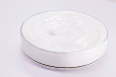 Petri dish with Benzoyl Peroxide cream, used in the preparation of cream, soap, lotion or gel in the treatment of acne and dermatosis. clipart