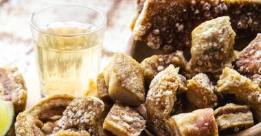 Domuz eti, kızarmış domuz eti, tipik Brezilya aperatifi, arka planda cachaca, Minas Gerais 'den geleneksel yemekler.