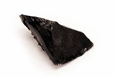 Siyah Obsidian, izole edilmiş beyaz arka planda siyah ve kristal cevher. Siyah renkli taş, tedavisel, meditasyonda kullanılır..