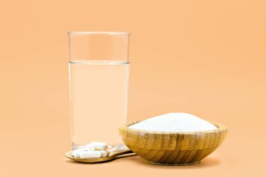 Bir kaşık hidrolize kolajen tozu, ve bir bardak suyla birlikte haplar, deri esnekliği için protein, izole edilmiş arka plan ve kopyalanmış alan
